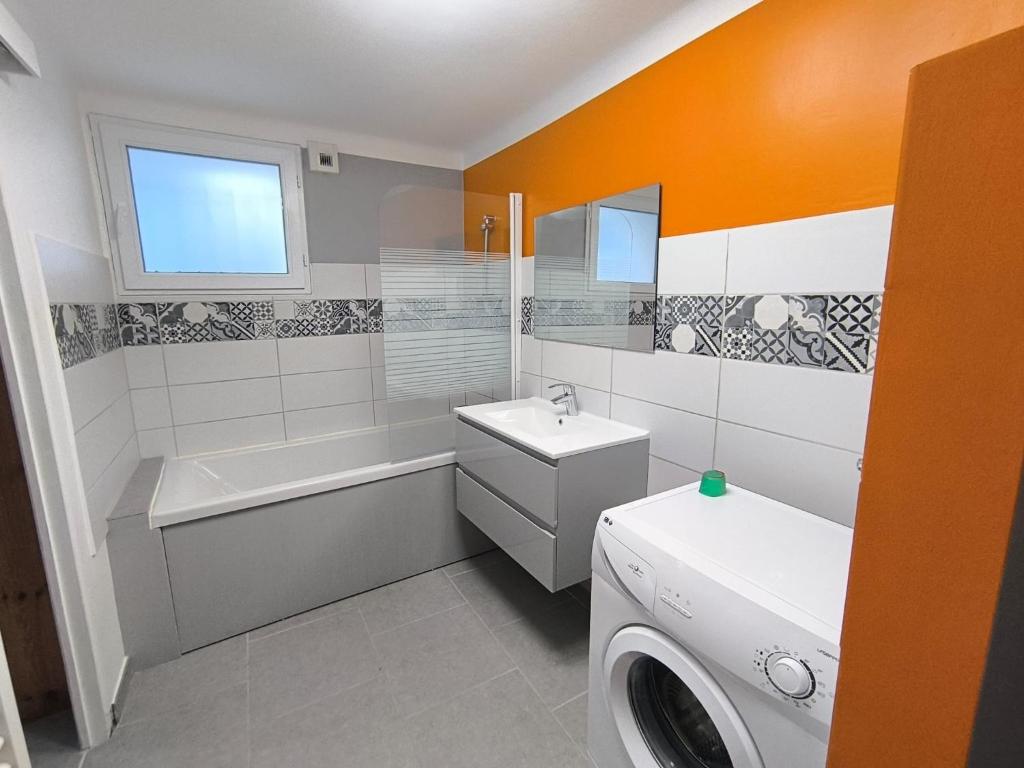 a bathroom with a sink and a washing machine at La Maison de la Baume in Volonne
