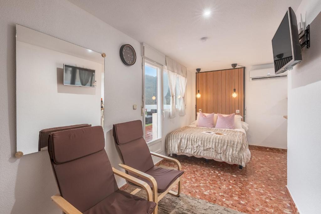 Una habitación de hotel con una cama y un televisor. en Estudio Sierra Nevada, en Güéjar-Sierra