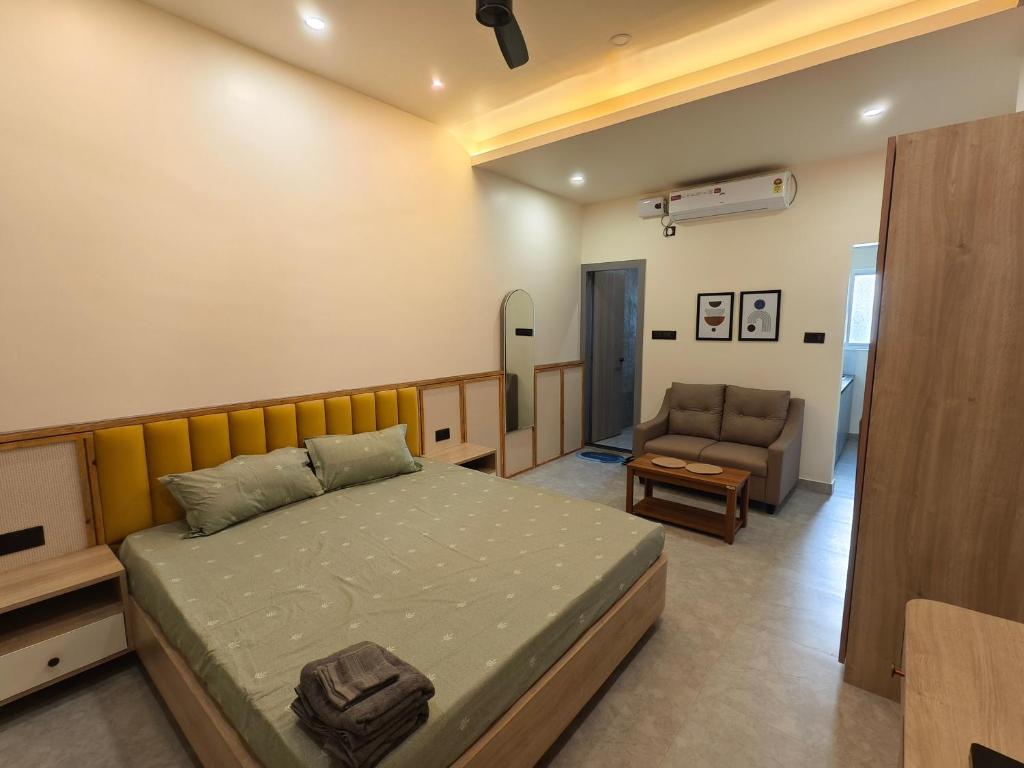 a bedroom with a bed and a couch and a chair at Cordial Host in Guwahati