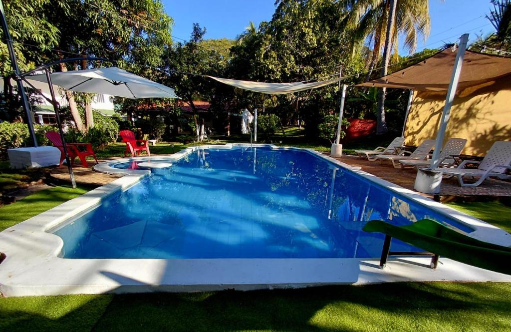 een zwembad met blauw water in een tuin bij Jardín Escondido in La Libertad
