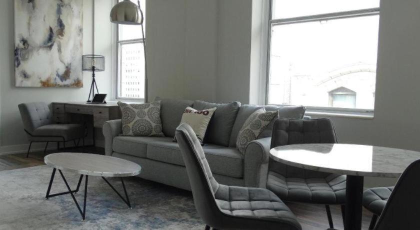 a living room with a couch and chairs and a table at The Chicago Hotel Collection Millennium Park in Chicago