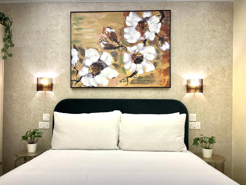 ビルキルカラにあるRosalina Residencesのベッドルーム1室(白いベッド1台、上に絵画付)