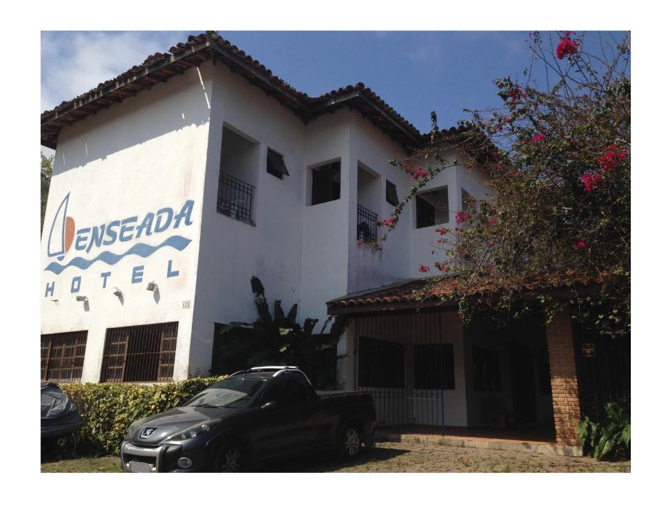 a black car parked in front of a building at Enseada Hotel in Ubatuba