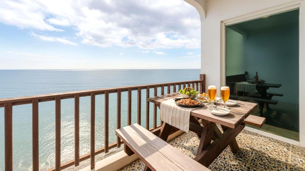 Una mesa en un balcón con vista al mar. en Youngduk Sea & Spa Pension, en Yŏngdŏk