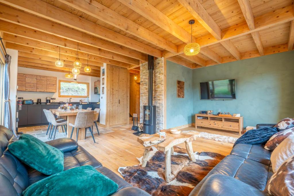 a living room with a couch and a table at Chalet cosy et neuf, Grande Terrasse, Vue panoramique in Saint-Jean-de-Sixt