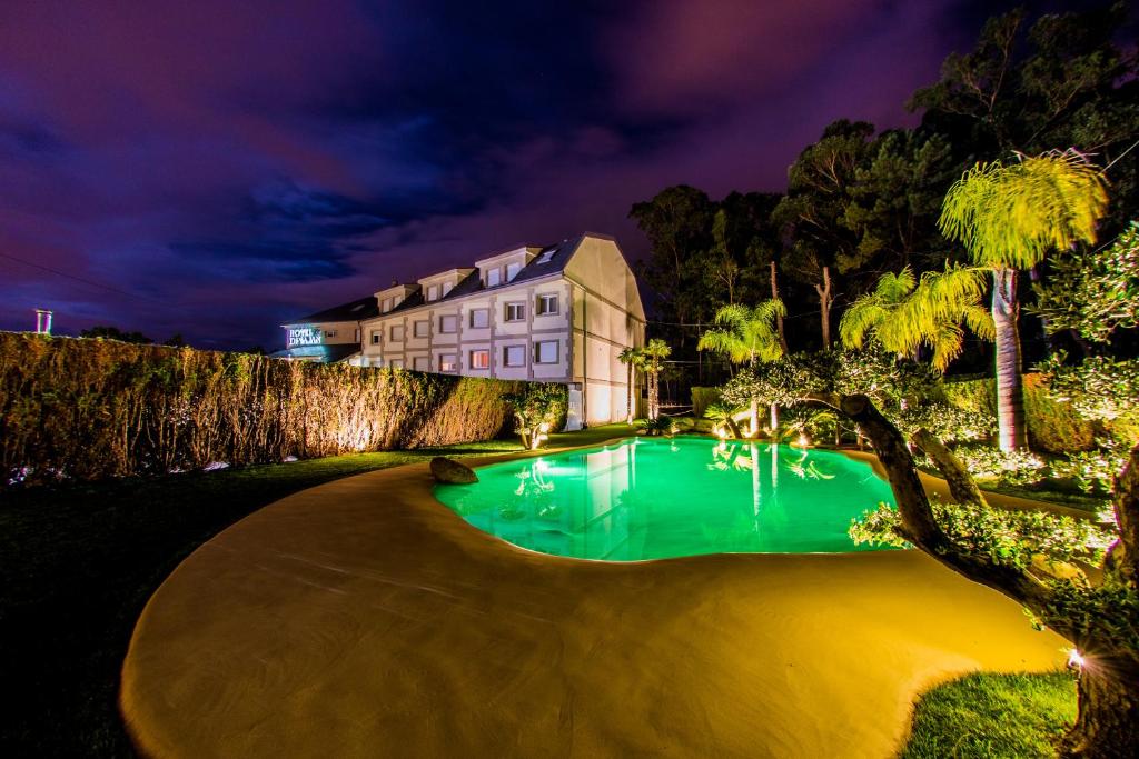 una casa con piscina por la noche en Hotel Dinajan, en Villanueva de Arosa