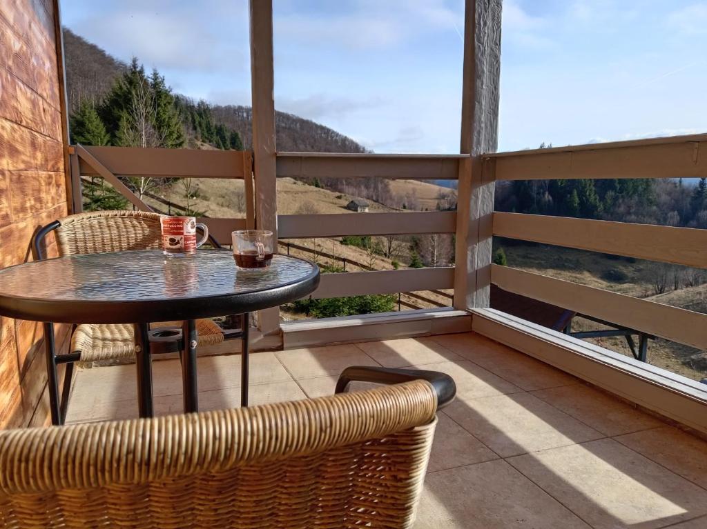 a table and chairs on a balcony with a view at Independent Chalet in Şirnea
