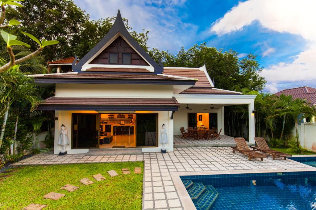 a house with a swimming pool in front of it at Champagne Villa by G Estate in Rawai Beach