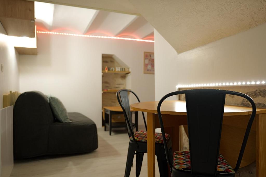 een kamer met een tafel, stoelen en een bank bij Charmant studio cœur de ville et proche plage in Les Sables-dʼOlonne