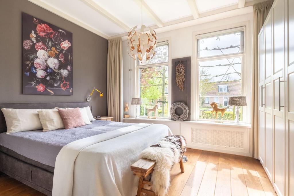 a bedroom with a bed with a blue comforter at Noardlik B&B in Burdaard