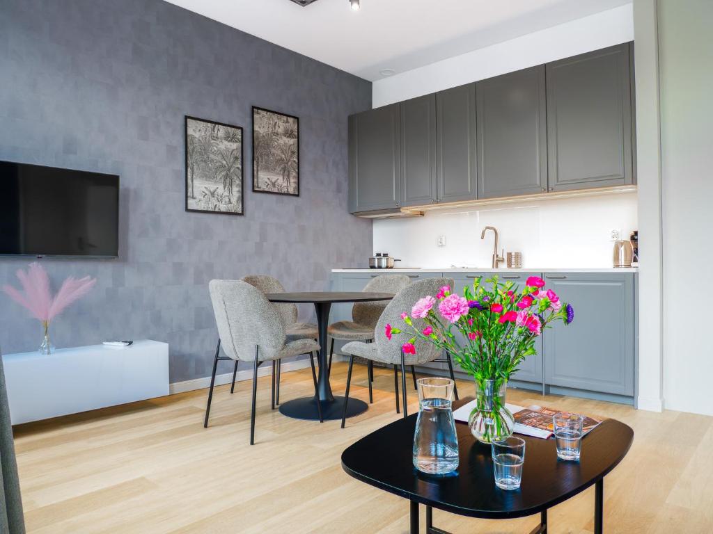 Una cocina y una sala de estar con mesa y sillas. en Długa 17 Residence, en Cracovia