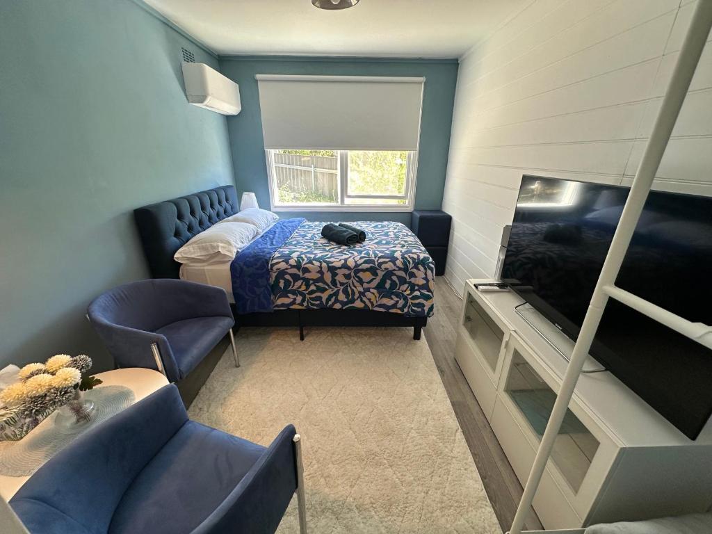 ein kleines Zimmer mit einem Bett und einem Fernseher in der Unterkunft Canberra Hospital Blue Daisy- Sleep & Go in Phillip