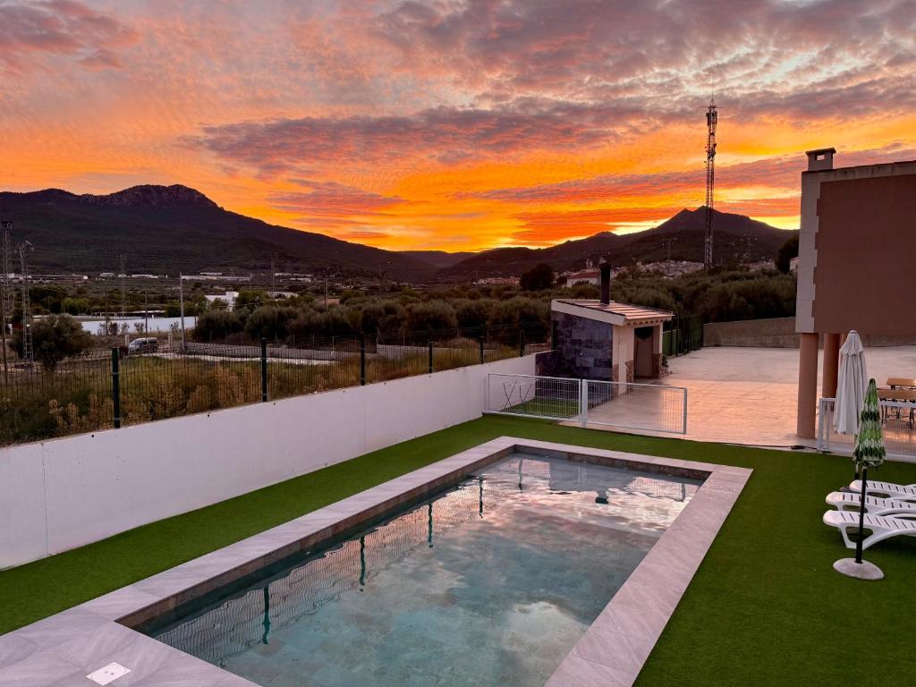 a pool on the roof of a house with a sunset at VILLA RINCON DEL BUITRE in Moratalla