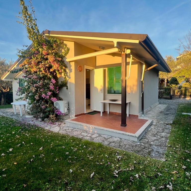 a small yellow house with a wooden deck at Villa Angiolina in Bardolino