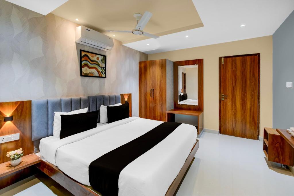 una camera da letto con un grande letto bianco in una stanza di Hotel O Sri Aditya Utsav a Hakīmpet