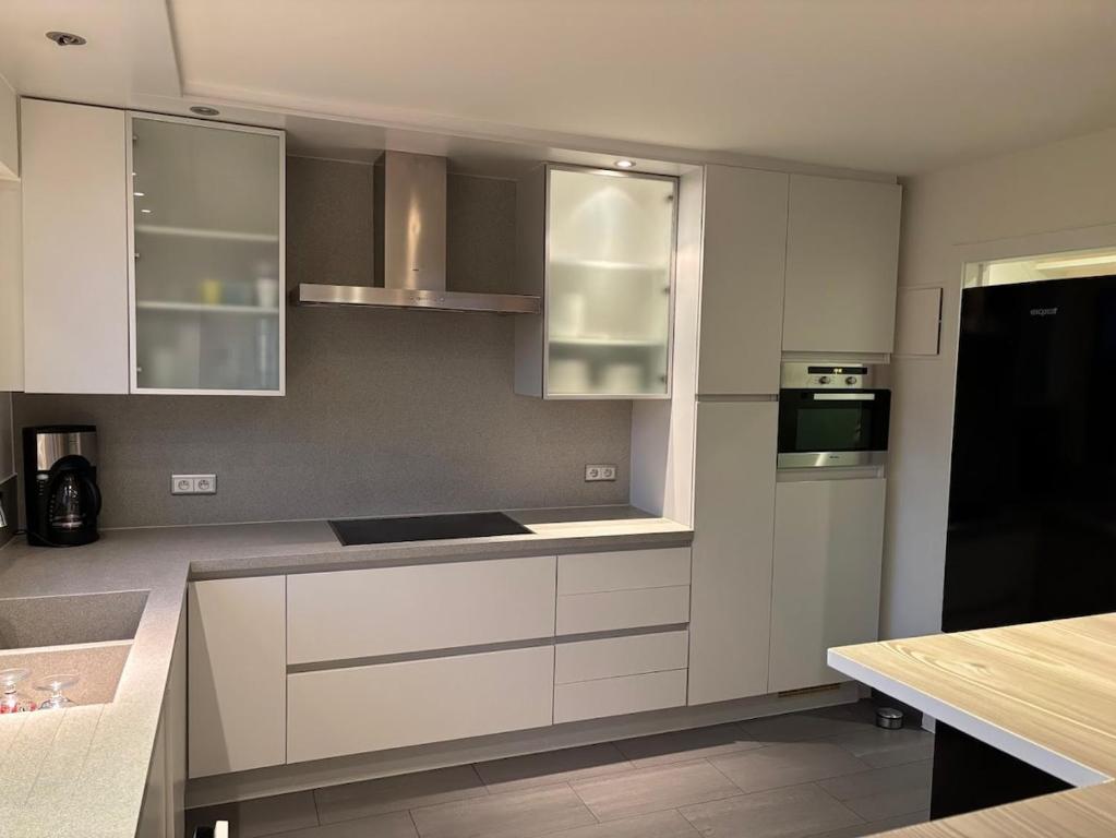 una cocina con armarios blancos y un aparato negro en Holiday home in Bredene space & fun by the sea, en Bredene