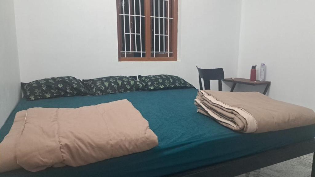 a bed with a green comforter in a room at MistyKera in Vattavada