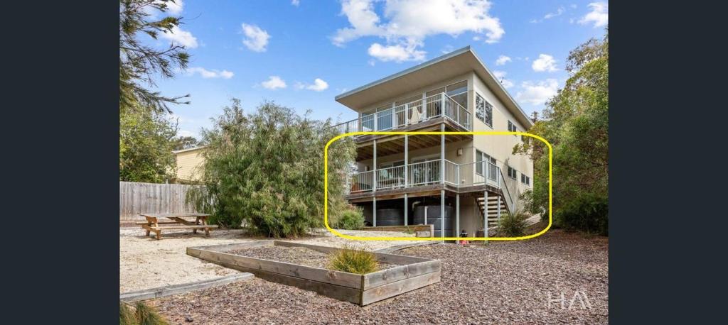 a large house with a yellow circle around it at 20 Bradley in Coles Bay