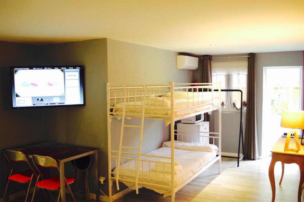Habitación con 2 literas y TV. en Hotel Apartamentos Rock Star, en Taboadela
