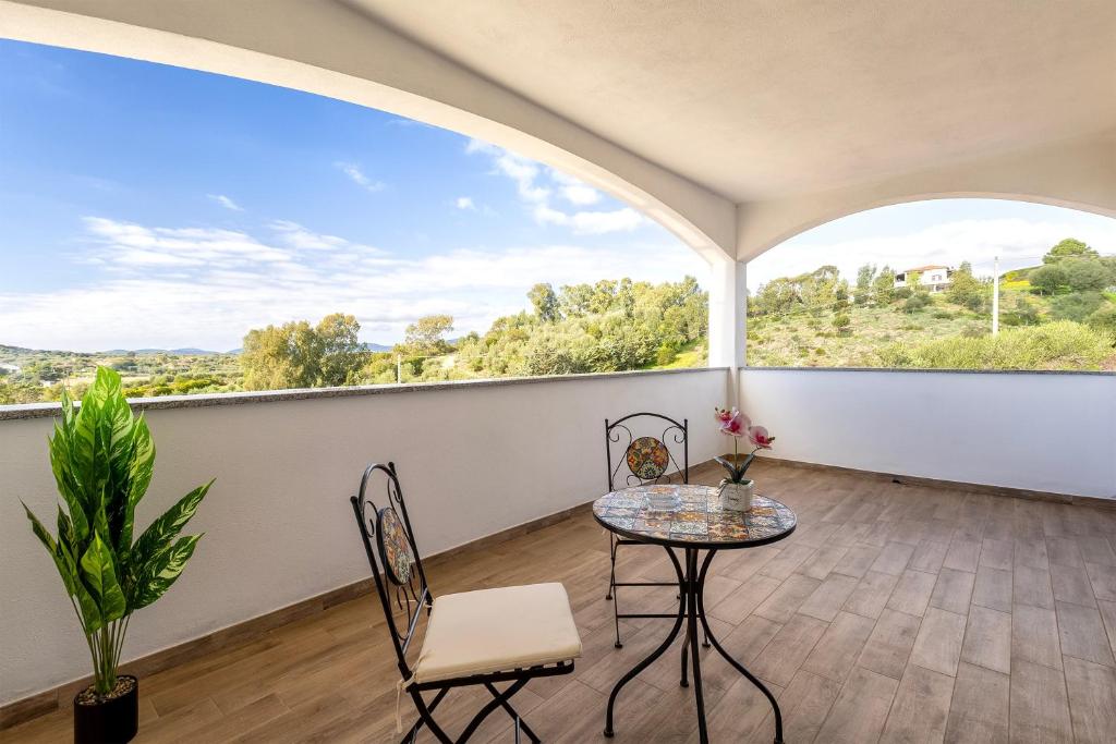 an empty room with a table and chairs and a large window at New and Vintage Villa - Anni 70' in Alghero