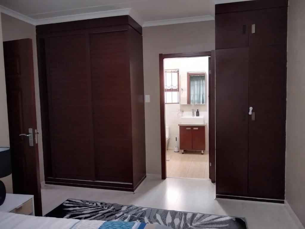 een slaapkamer met een deur naar een badkamer bij Two Lilies in Vosburg