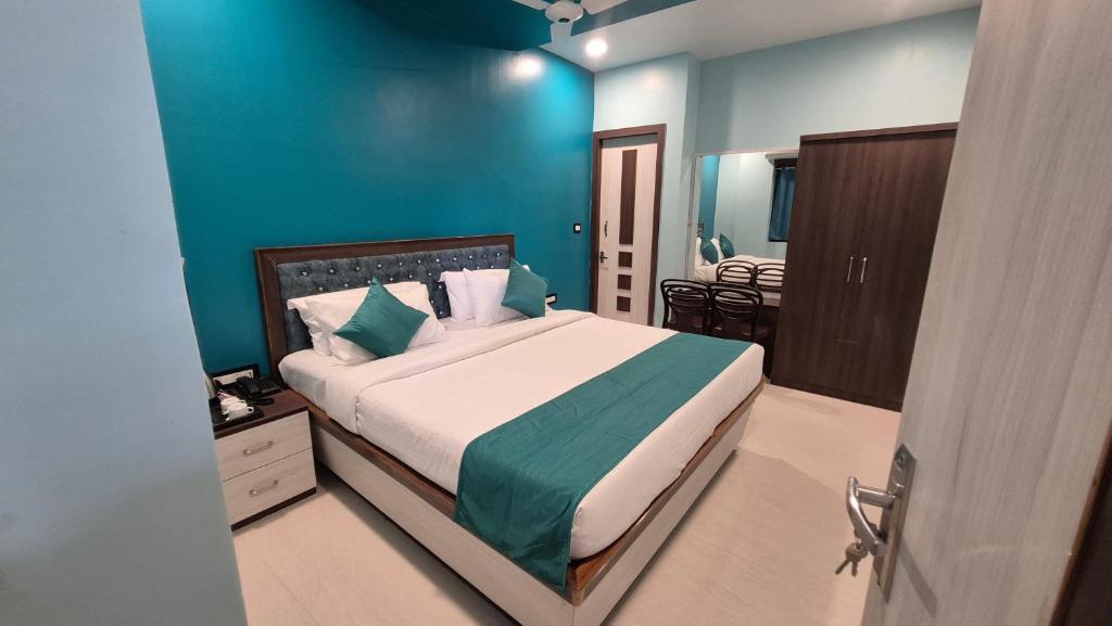 Un dormitorio con una cama y una pared azul. en Hotel City Palace, en Bhagalpur