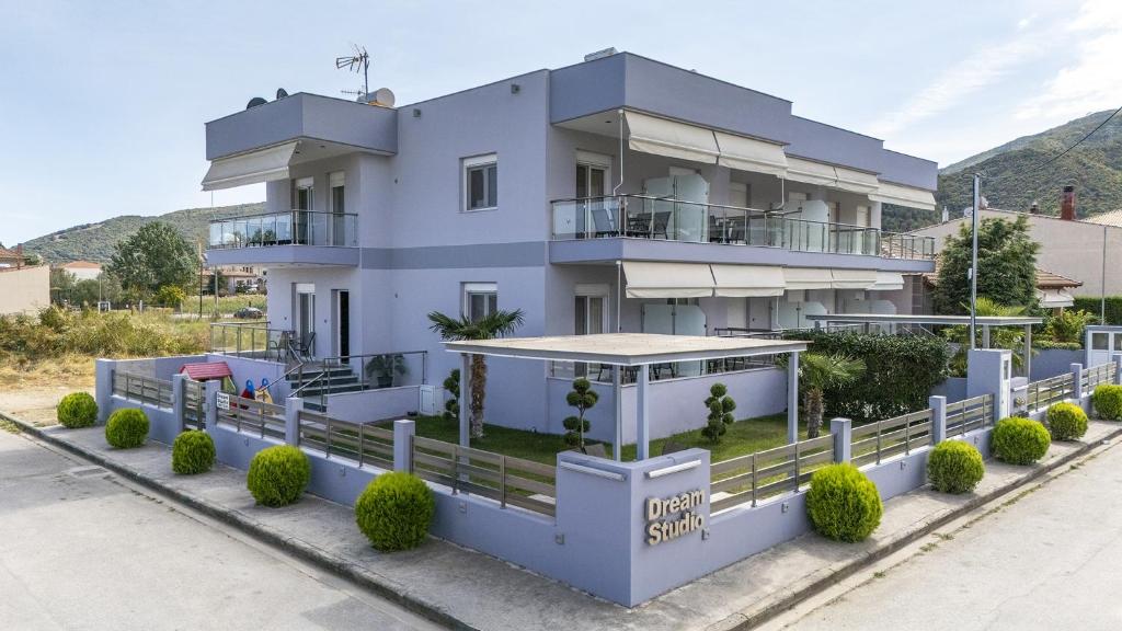 a white house with a fence in front of it at Dream Studios in Stavros