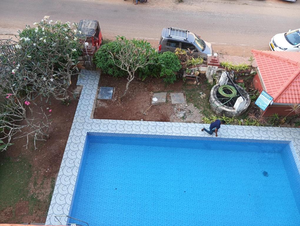 Un hombre de pie junto a una piscina azul. en The Tourist Street, en Cavelossim