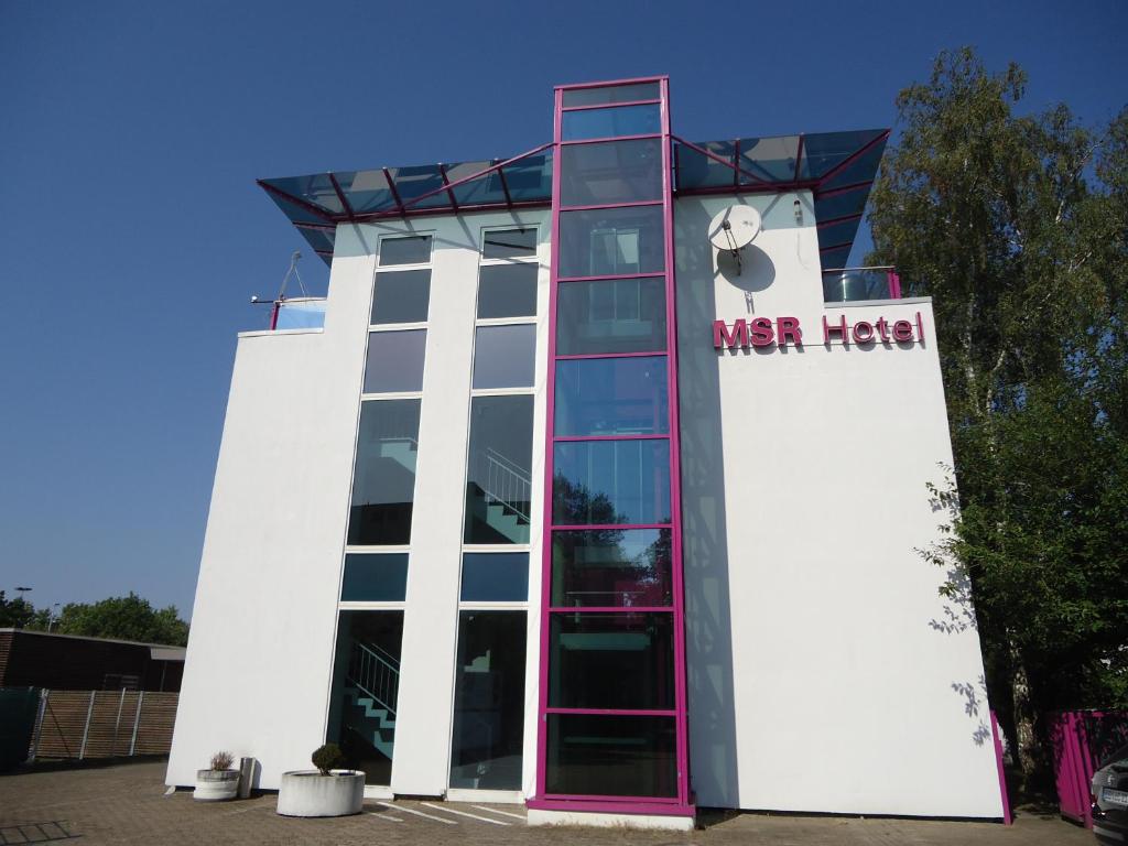 um edifício branco com um cartaz em MSR Hotel Hannover em Hanôver