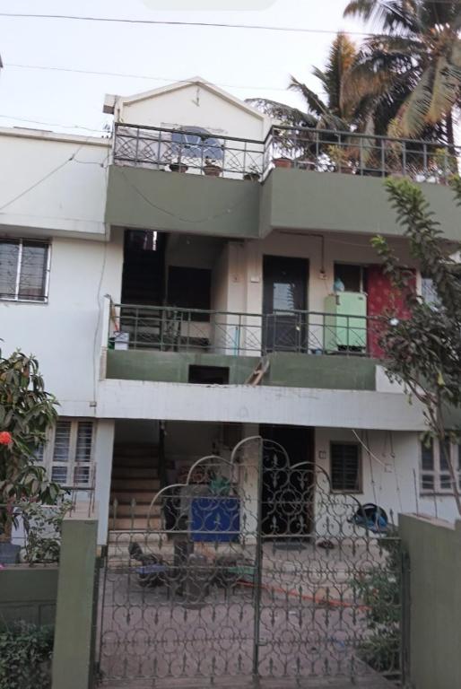 an apartment building with a balcony and a staircase at Cherry On The Top Homestay with AC in one bedroom in Kolhapur