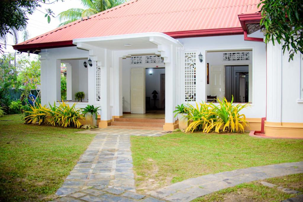 a white house with a red roof at The Cozy Villa in Ambalangoda