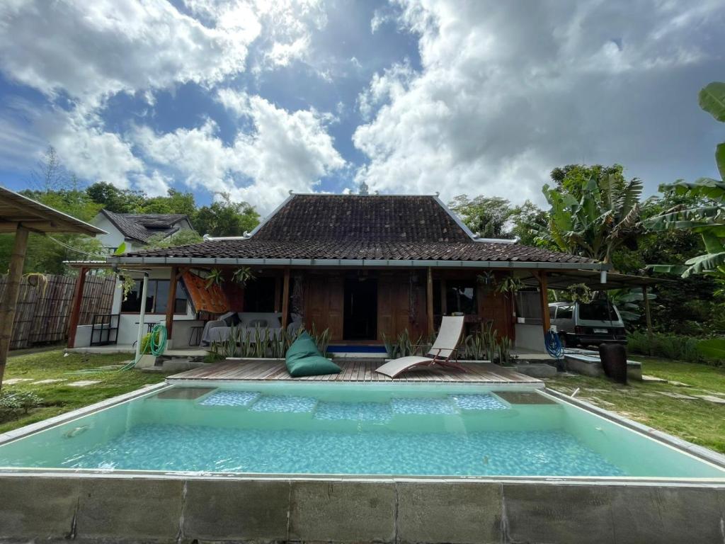 una villa con piscina di fronte a una casa di Villa Velo One a Watumurah