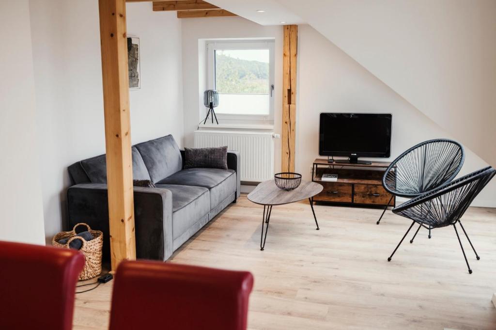 een woonkamer met een bank en een tv bij Ferienwohnung Habichthorst in Naumburg