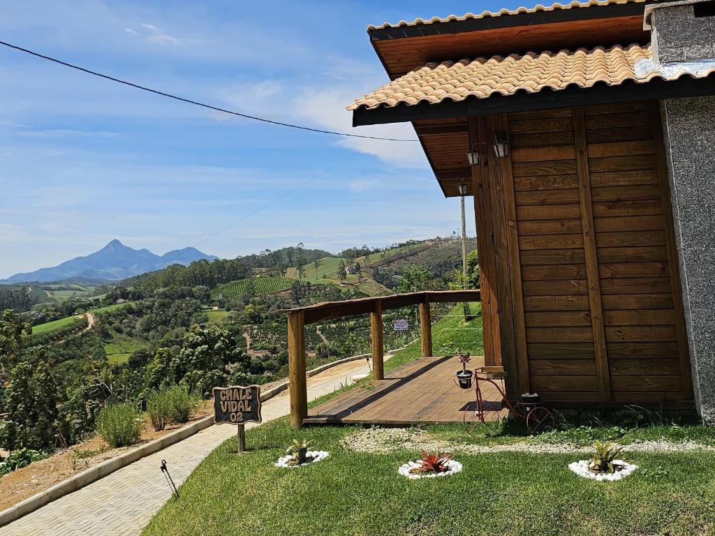 Una casa con una puerta de madera y un cartel en el césped. en Chales Vidal, en Venda Nova do Imigrante
