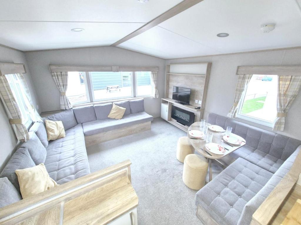 ein Wohnzimmer mit Sofa und Tisch in der Unterkunft Birchington Vale Arizona in Westgate-on-Sea
