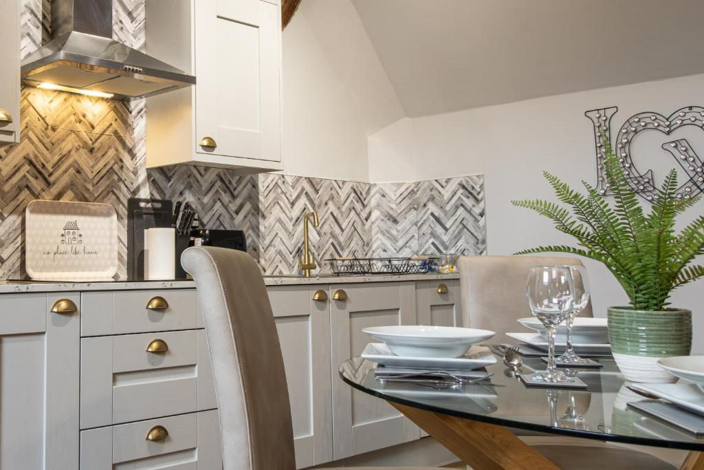 een keuken met een glazen tafel en een aanrecht bij Blists Hill Cottage Near Ironbridge Victorian Museum in Telford