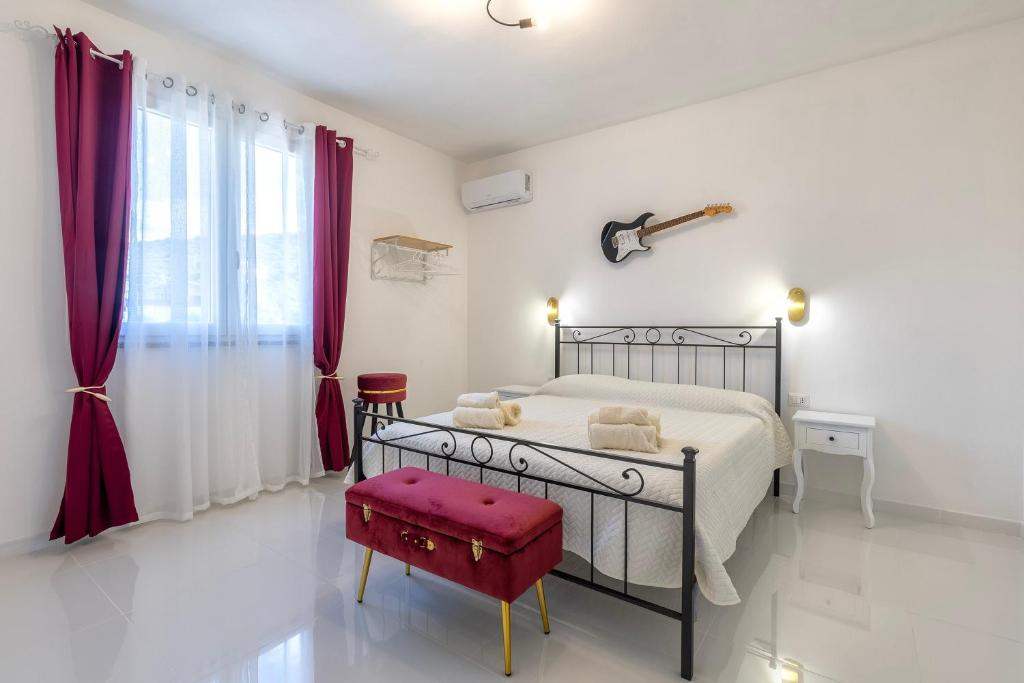 a bedroom with a bed and a red stool at New and Vintage Villa - Anni 50' in Alghero