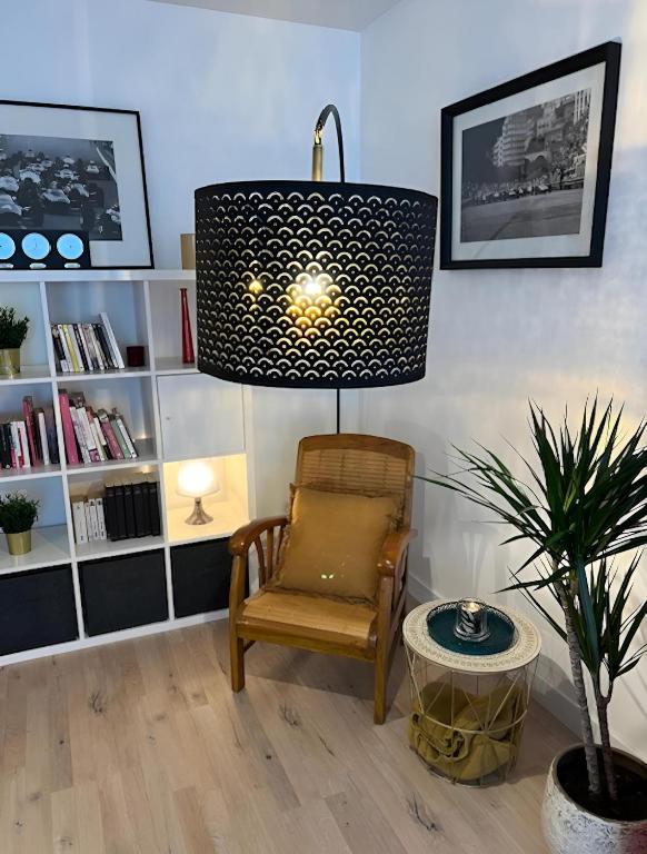 a living room with a chair and a lamp at Appartement centre Orsay in Orsay