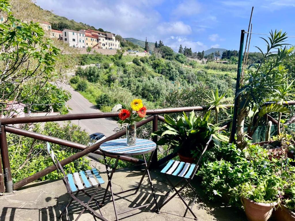 a table with a vase of flowers on a balcony at Casa Ariel - Elba Affitti in Rio nellʼElba