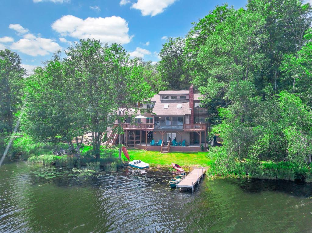 a house on a river with a dock in the water at Lakefront Big Bass Lake Dock Games in Gouldsboro