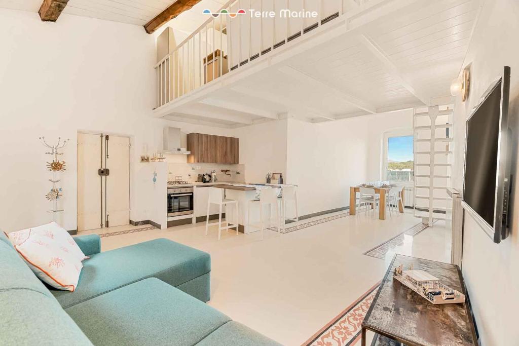 een woonkamer met een blauwe bank en een keuken bij Casa al Quarto, Terre Marine in Fezzano