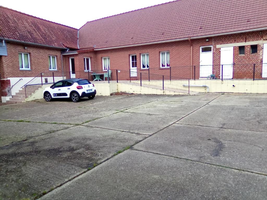 een auto geparkeerd op een parkeerplaats naast een gebouw bij Gites du Beaucaine in Fiefs