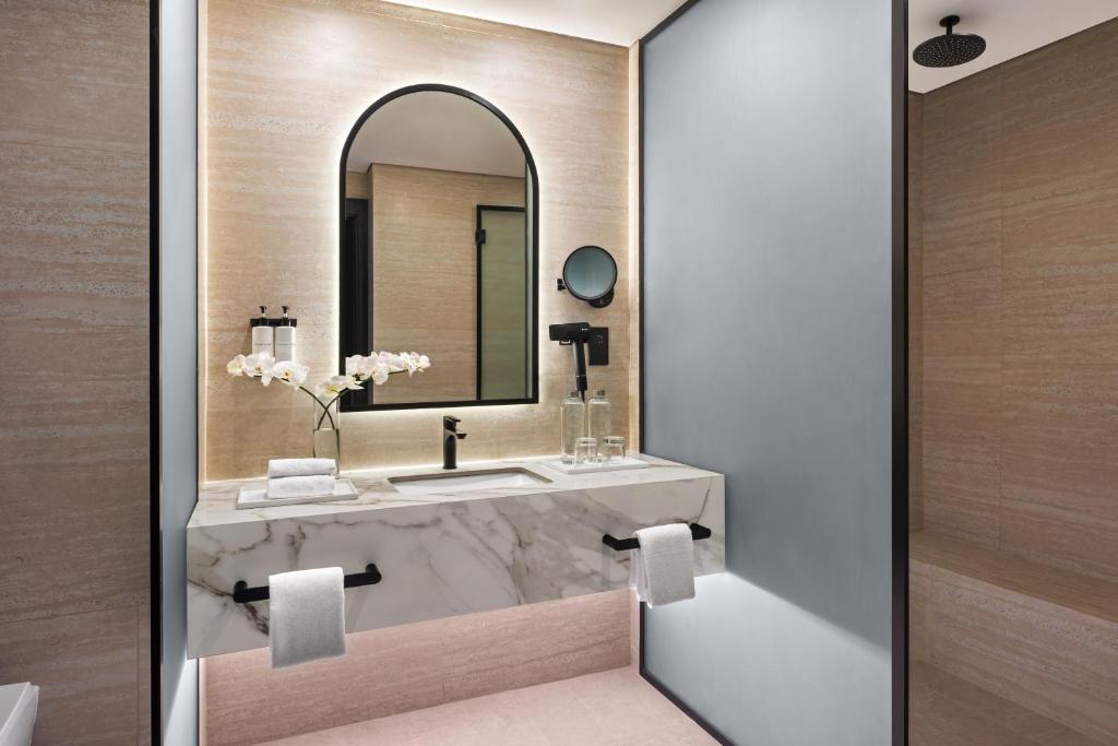 a bathroom with a sink and a mirror at Oaks Ibn Battuta Gate Dubai in Dubai