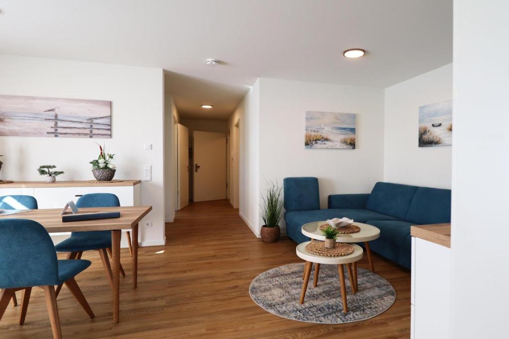 Una sala de estar con un sofá azul y una mesa. en Küste33-15 - Strandnest, en Tossenserdeich