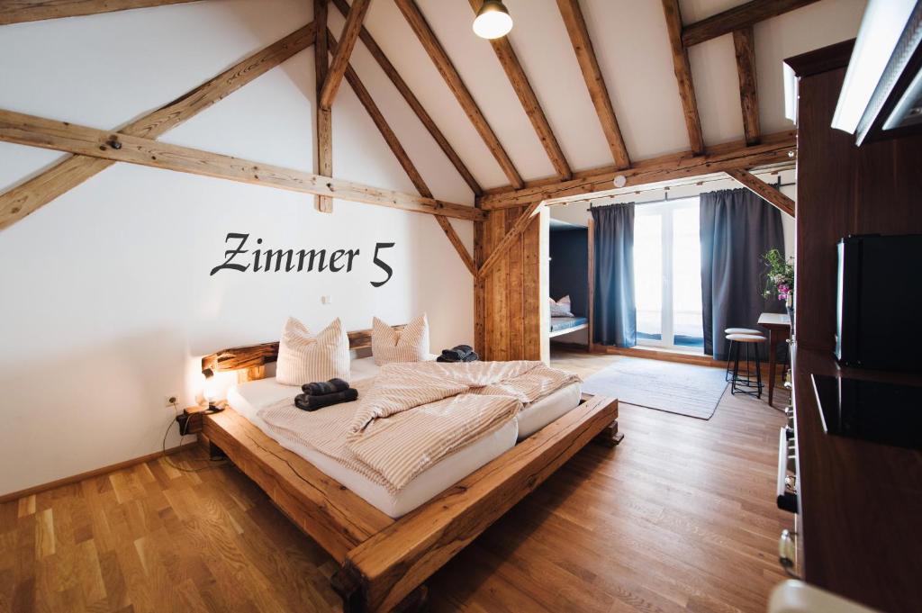 ein Schlafzimmer mit einem großen Bett in einem Zimmer mit Holzdecken in der Unterkunft Alte Kass Hotel & Kaffeehaus in Neidlingen