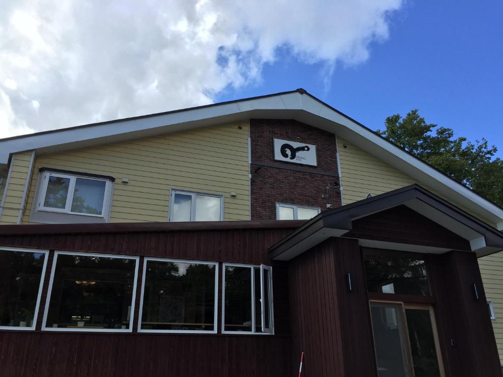 a house with a clock on top of it at Pension Fryingpan in Niseko