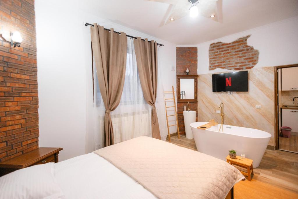 a bedroom with a bed and a bath tub and a sink at Marcos Apartments I Bathtub in Bedroom experience in Făgăraş
