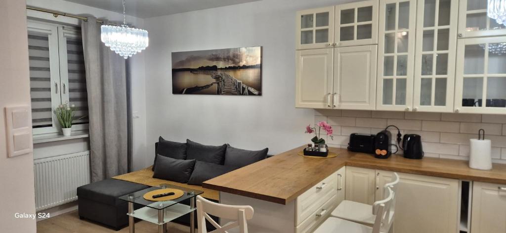 een keuken met een tafel en een bank in een kamer bij Apartament SORENTO 25 in Gorzów Wielkopolski