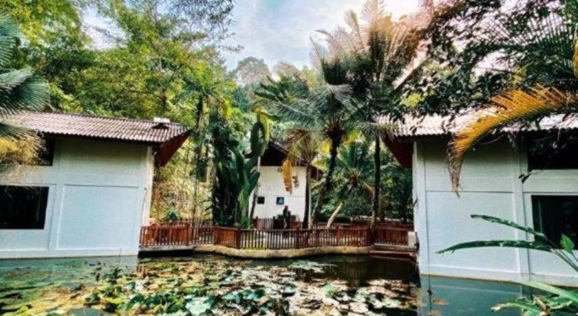 a house with a koi pond in front of it at Bidaisari Resort in Kampong Sum Sum
