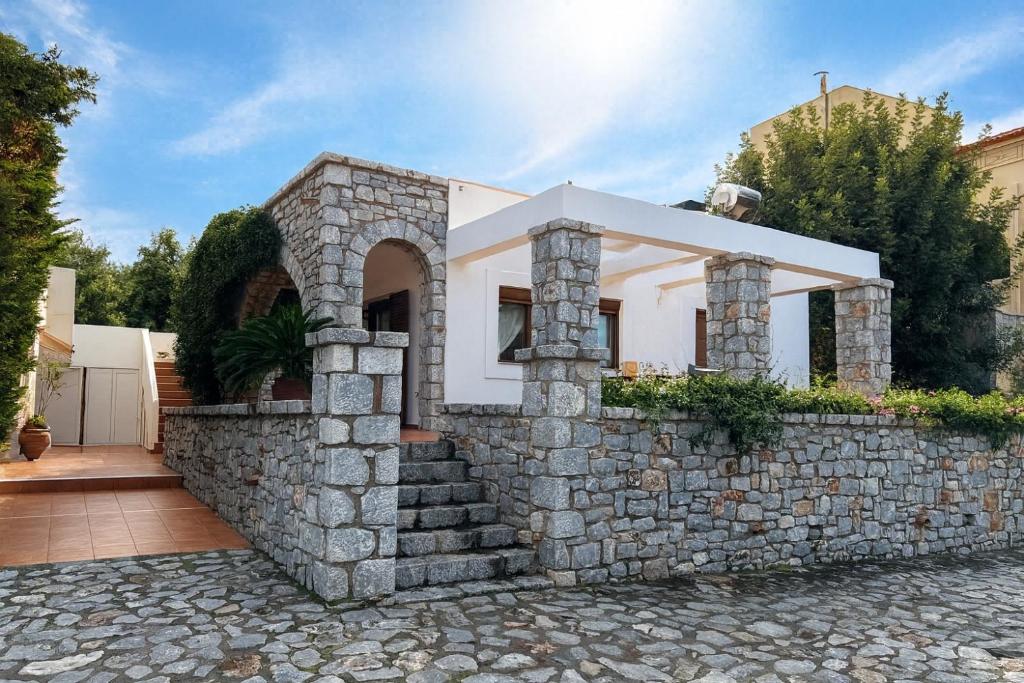 eine Steinmauer vor einem Haus in der Unterkunft Jassemi Studio in Mavrovouni